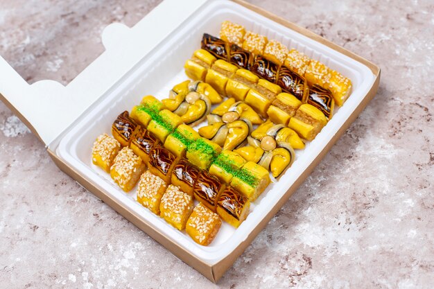 Traditional oriental sweets with different nuts on concrete  background, top view, copy space