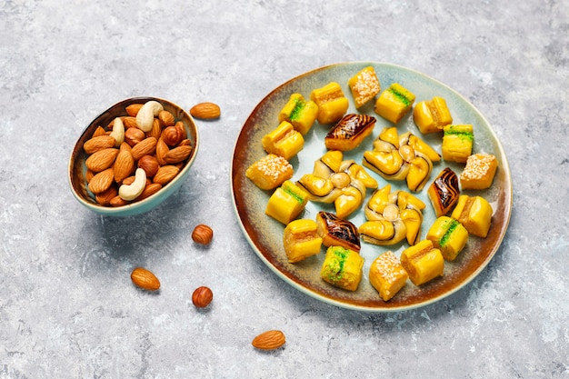 Traditional oriental sweets with different nuts on concrete surface