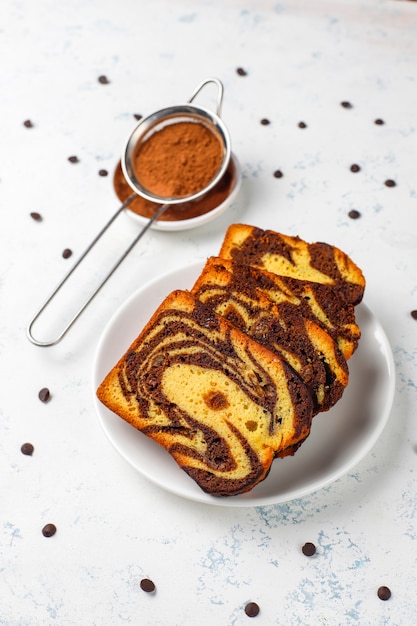 Free photo traditional raisin marble cake slices with raisins and cocoa powder, top view