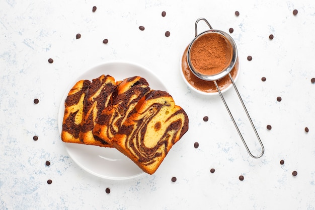 Free photo traditional raisin marble cake slices with raisins and cocoa powder, top view