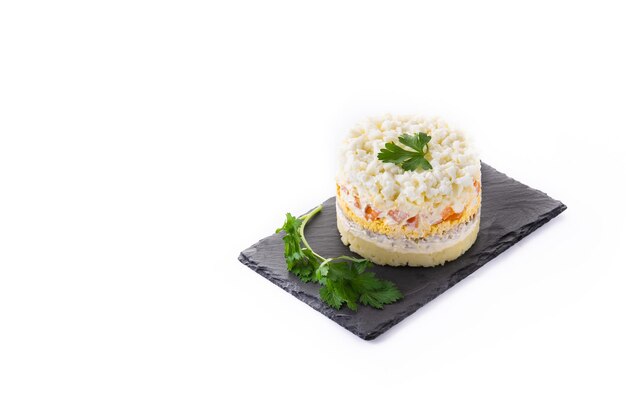 Traditional Russian layered salad Mimosa isolated on white background