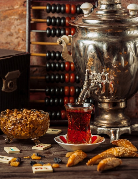 Foto gratuita set da tè samovar tradizionale con varietà di snack, dolci e frutta secca.