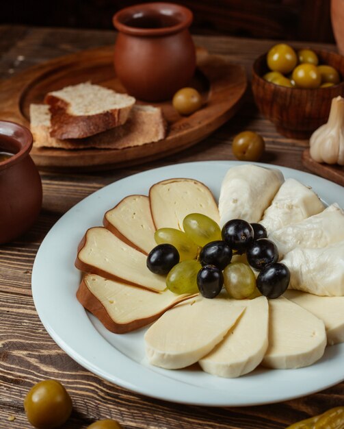 Традиционная установка для сырной тарелки с копченым, белым, козьим сыром, виноградом