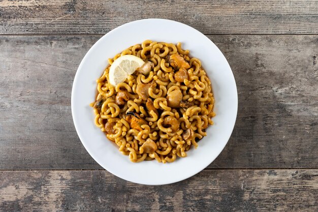 Traditional Spanish fideua Noodle paella on wooden table