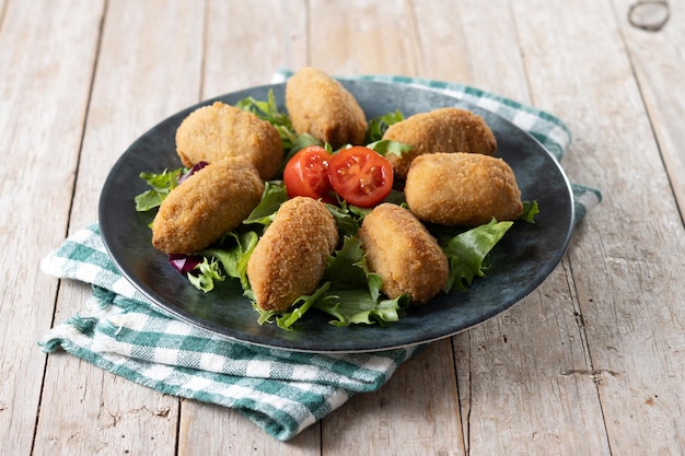 Traditional spanish fried croquettes on wooden table