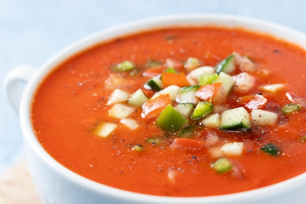 Foto gratuita zuppa di gazpacho spagnolo tradizionale in ciotola su sfondo blu