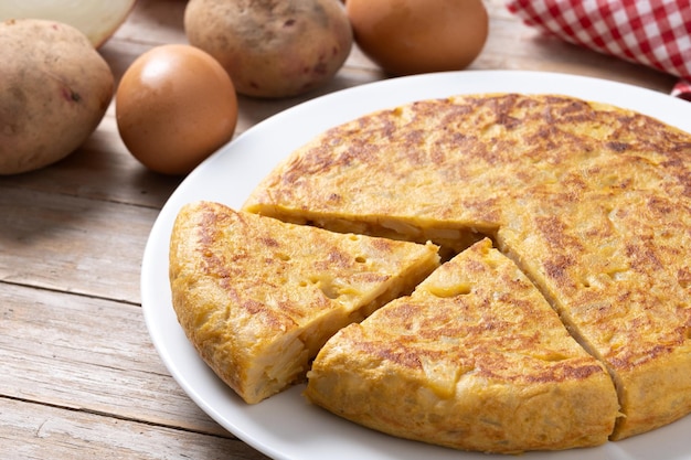 Free photo traditional spanish omelette with ingredients on wooden tablexa