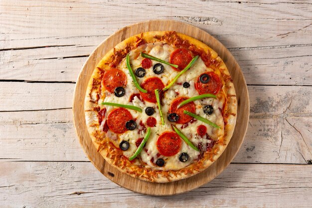 Traditional supreme pizza on rustic wooden table