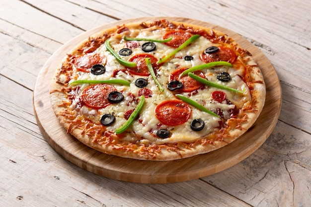 Free photo traditional supreme pizza on wooden table