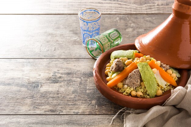Premium Photo Traditional Tajine With Vegetables Chickpeas Meat And Couscous On Wooden Table