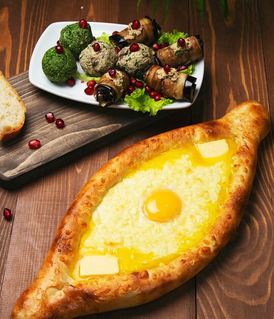 Traditional turkish baked dish pide. Turkish pizza pide with cheese and egg with vegetable salad. 