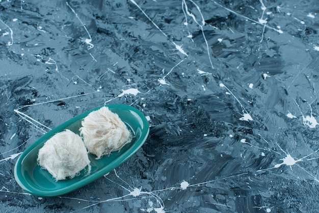 Traditional Turkish cotton candies on a plate, on the blue background. 