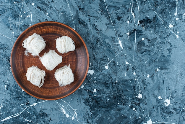 Traditional Turkish cotton candies on a wooden plate , on the blue table. 