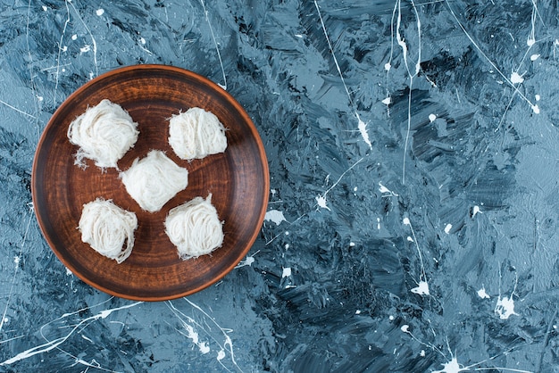 Traditional Turkish cotton candies on wooden plate on blue. 
