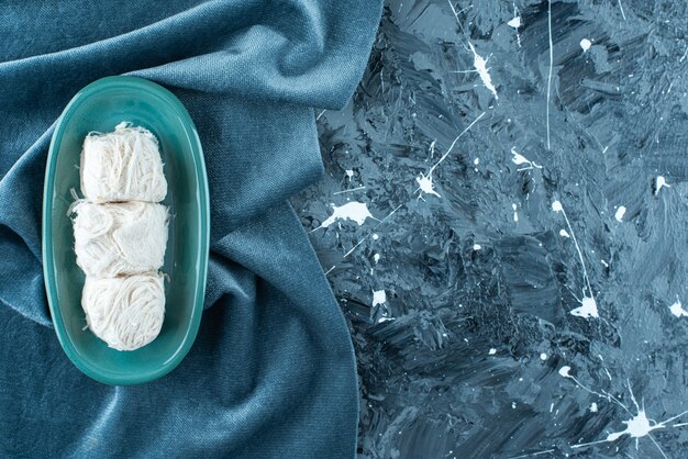 Traditional Turkish cotton candy on plate on towel on blue. 