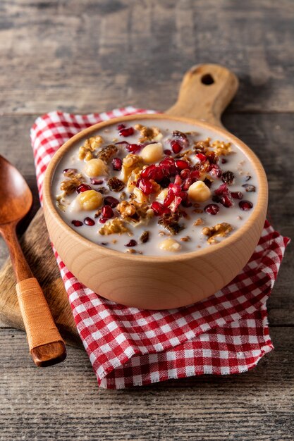 Traditional Turkish Noah's pudding in bowl on wooden table