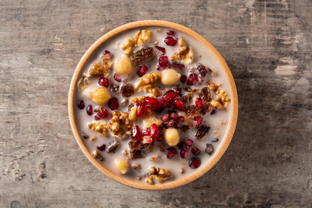 Traditional Turkish Noah's pudding in bowl on wooden table