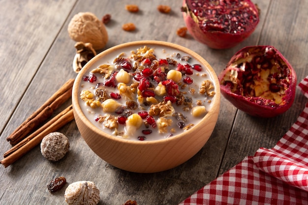 Traditional Turkish Noah's pudding in bowl on wooden table