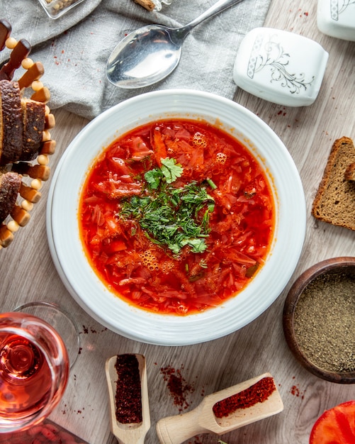  traditional ukrainian borscht with slices of brown bread and a soft drink