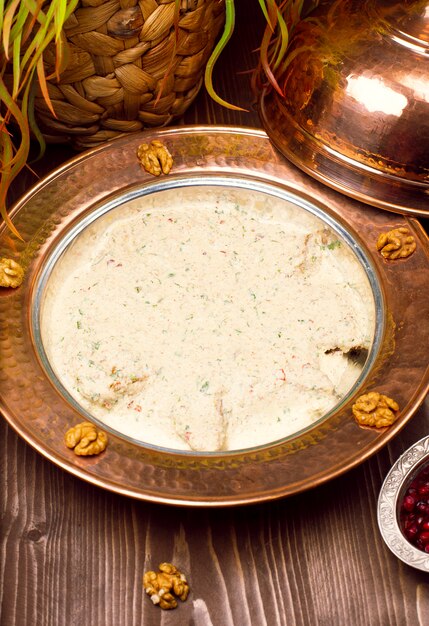Traditional yayla soup (yoghurt soup) in copper plate with walnuts 