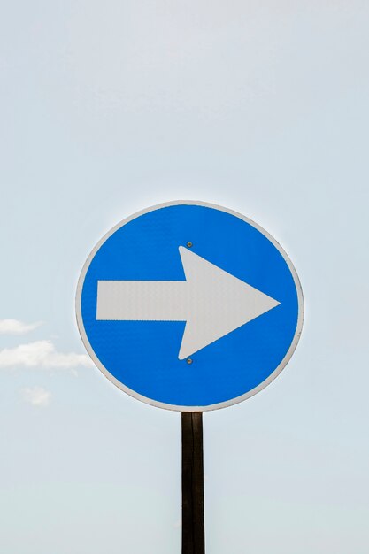 Traffic arrow sign and sky with clouds