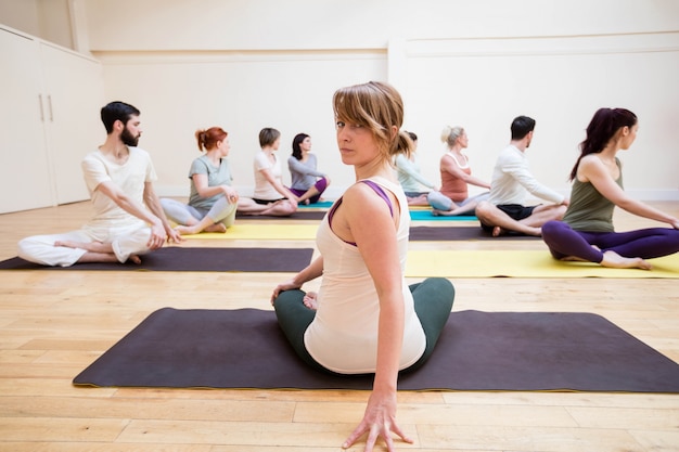 Trainer assisting group of people with stretching exercise