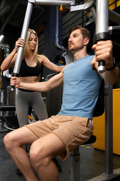 Trainer helping beginner at the gym