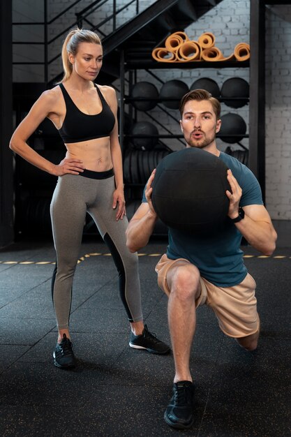 Trainer helping beginner at the gym