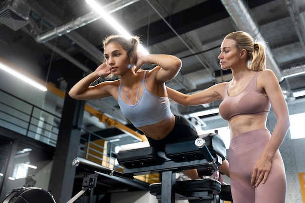 Trainer helping beginner at the gym