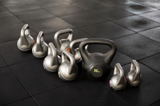 Training at gym concept with kettlebells high angle