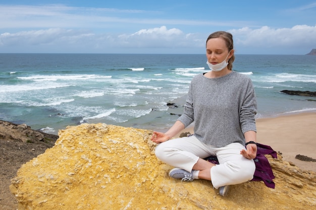 Tranquil woman in face mask practicing yoga