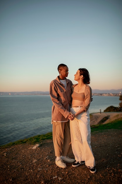 Free photo trans couple holding each other at sunset on the beach