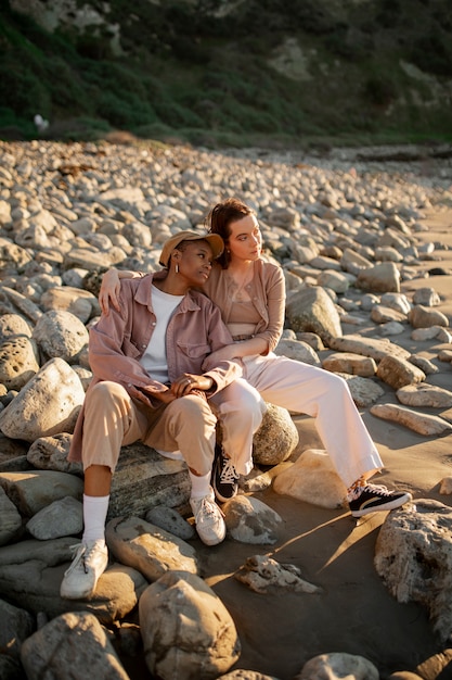 Free photo trans couple watching the sunset on the beach