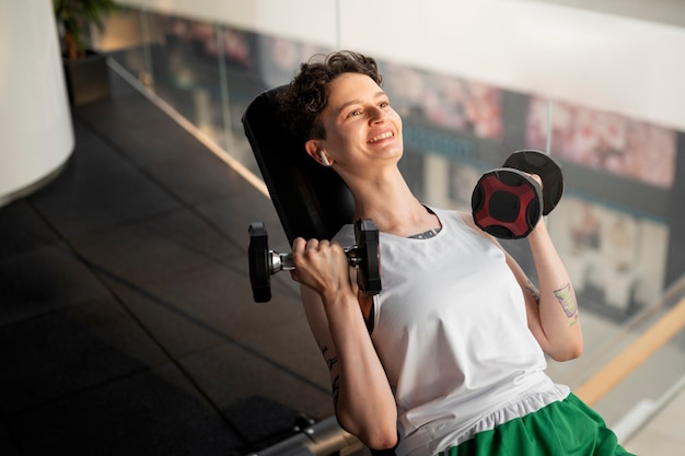 Free photo trans man exercising at the gym