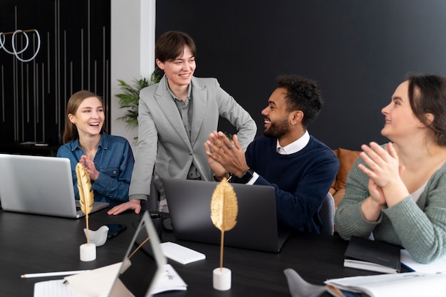 Persona trans che lavora in ufficio con i colleghi