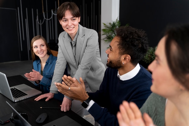 Persona trans che lavora in ufficio con i colleghi