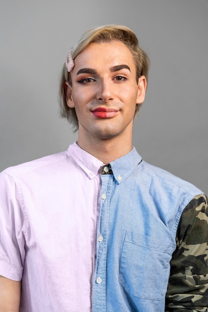 顔の半分に化粧をしているトランスジェンダーの男性
