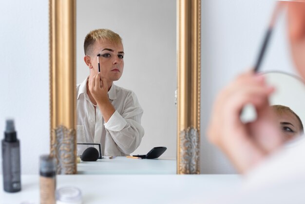 Transgender putting on makeup close up
