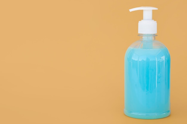 Transparent bottle of blue liquid soap with copy space
