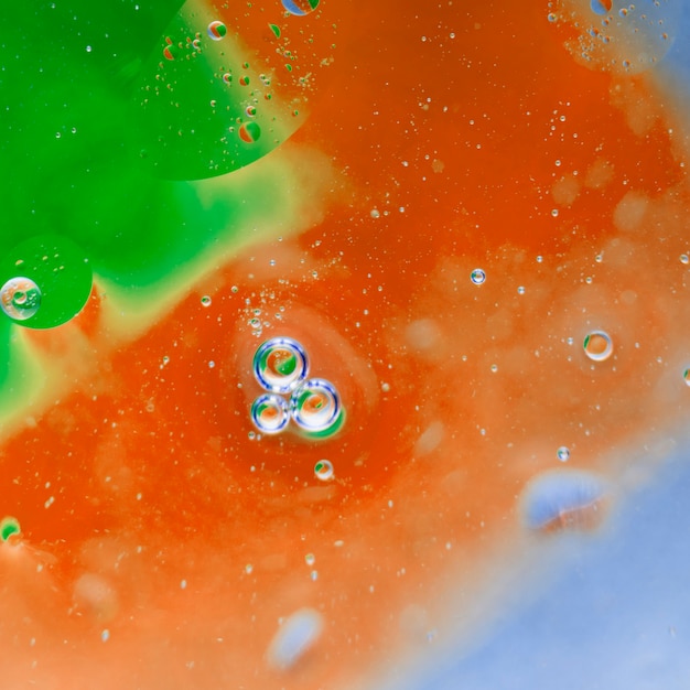 Transparent bubbles on green and an orange painted background