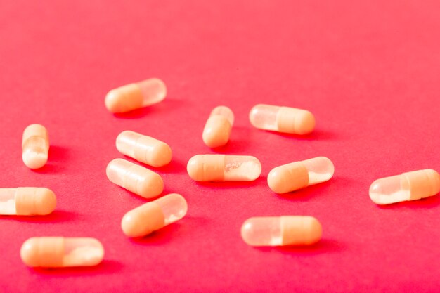 Transparent capsules over the red background