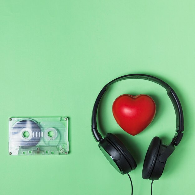 투명 카세트 테이프; 녹색 배경에 헤드폰 및 붉은 심장