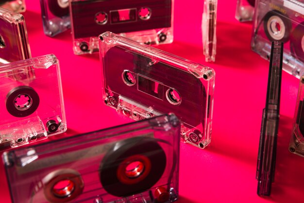 Transparent cassette tapes on pink background