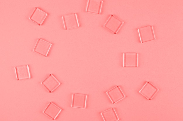 Transparent cubes arranged in circle shape against coral backdrop