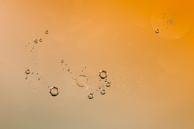 Transparent droplets on watery orange backdrop