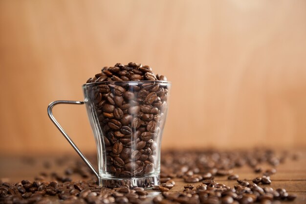 Transparent glass cup filled with coffee beans