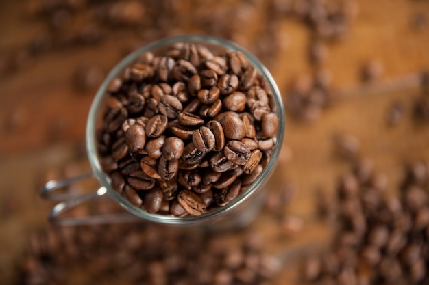 Transparent glass cup filled with coffee beans