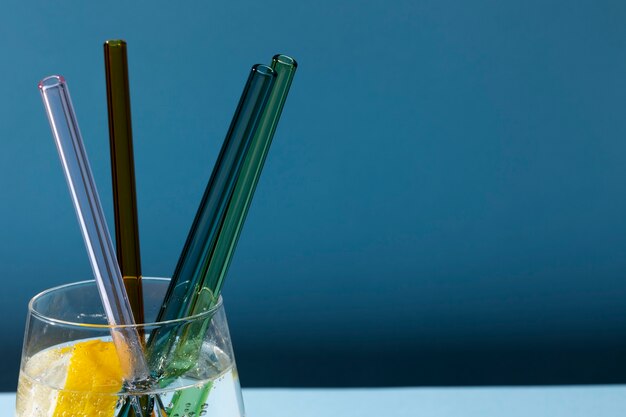 Transparent glass with fizzy water and colored glass straws