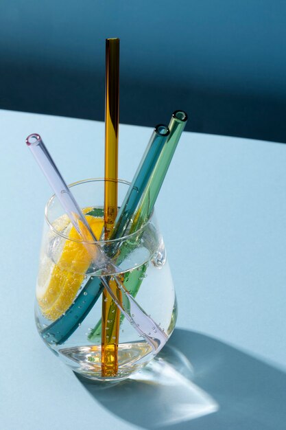 Transparent glass with fizzy water and colored glass straws