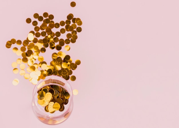 Transparent glass with golden confetti at party